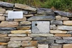 Sanierte Trockensteinmauer mit eingebautem Nistkasten.