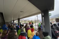 Groupe de personnes écoute le directeur sous la pluie