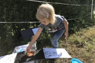 Petite fille remplis une gamelle dans le tunnel à trace ouvert