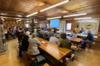 Les membres assis à des tables dans la Burgerstube de Gampel