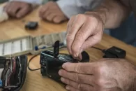 Gros plans sur de mains qui réparent un appareil photo