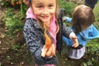 Enfant dehors tenant une carotte dans sa main